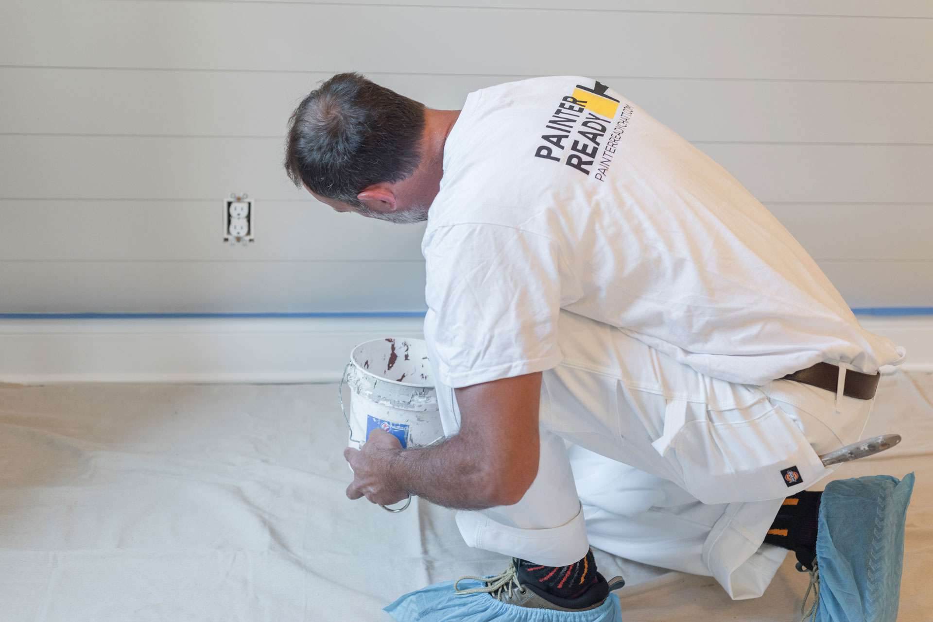 Painter applying paint to an interior wall